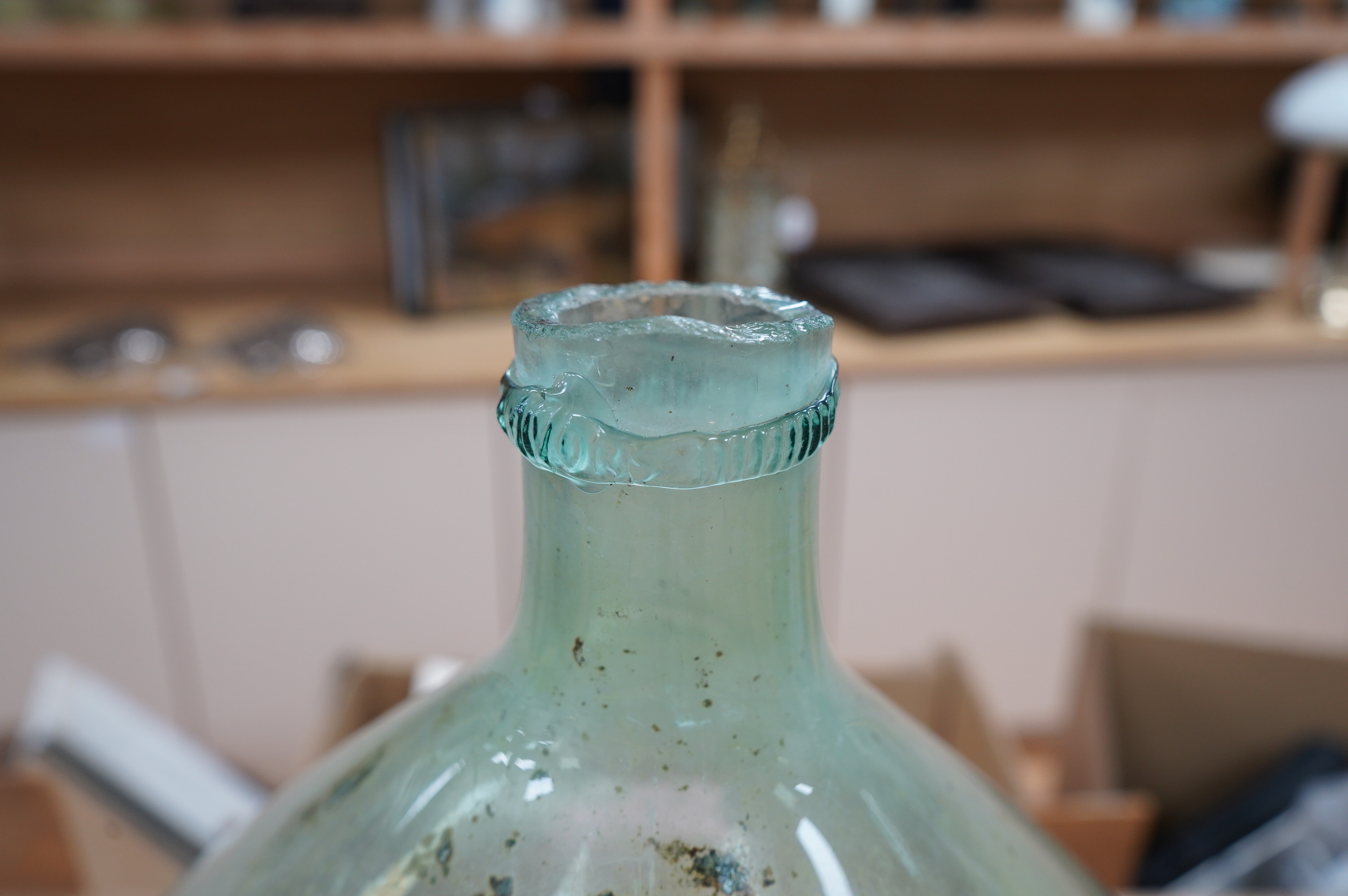 A large glass globular bottle, 48cm high. Condition - poor, significant staining and chipping to rim.